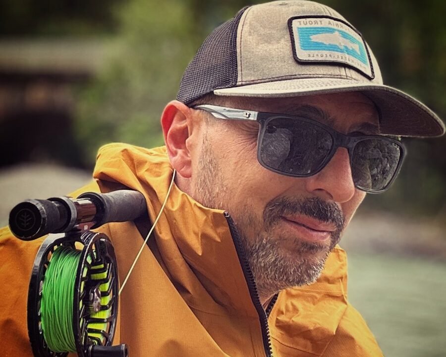Diego, professional fly fishing guide, casting his line into a crystal-clear river in the Italian Dolomites, Alto Adige.