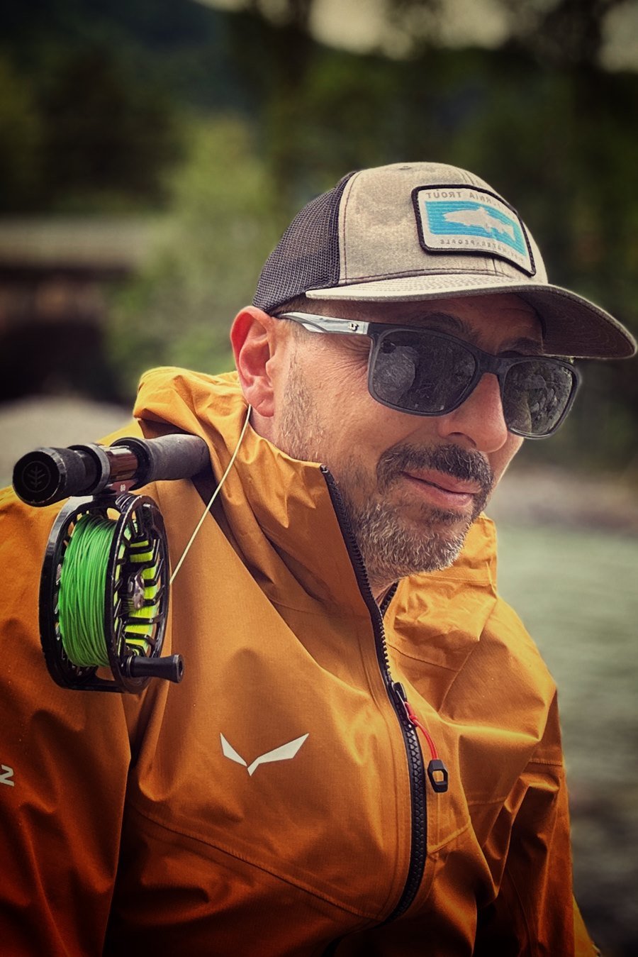Diego, professional fly fishing guide, casting his line into a crystal-clear river in the Italian Dolomites, Alto Adige.